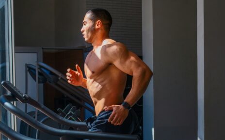 Man runs on a treadmill during a gym workout.