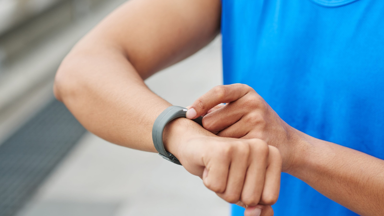 A person checks a fitness tracker on their wrist after exercise.