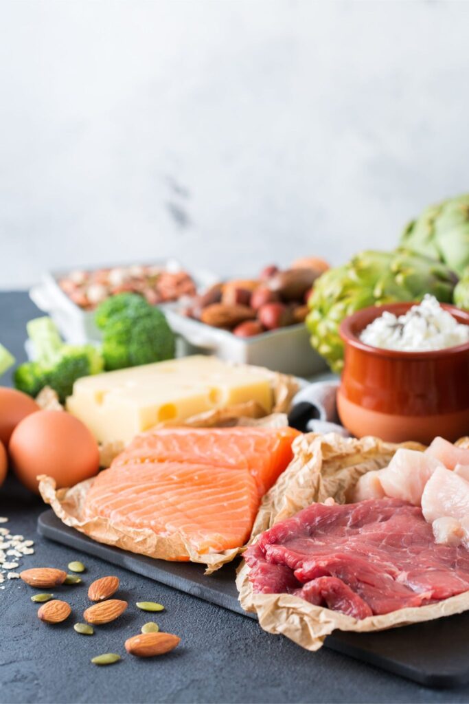 Assortment of healthy protein source and body building food. Meat beef salmon chicken breast eggs dairy products cheese yogurt beans artichokes broccoli nuts oat meal